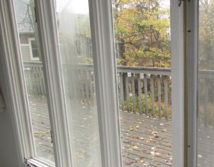 Foggy condensation trapped between double-pane glass showing failed hermetic seal requiring insulated glass unit replacement