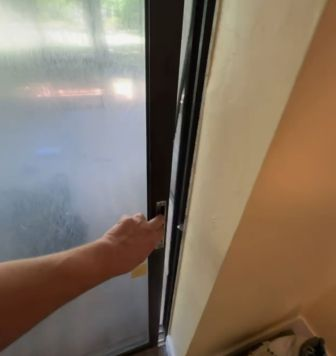 Technician testing door operation after roller replacement showing smooth one-finger glide