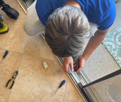 Close-up of technician removing worn roller assembly with specialized tools