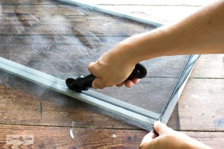 Technician using spline roller to install new screen mesh into aluminum frame groove