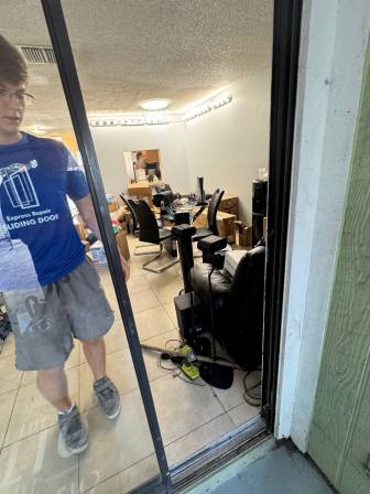 Technician performing final testing showing smooth effortless door glide after track repair